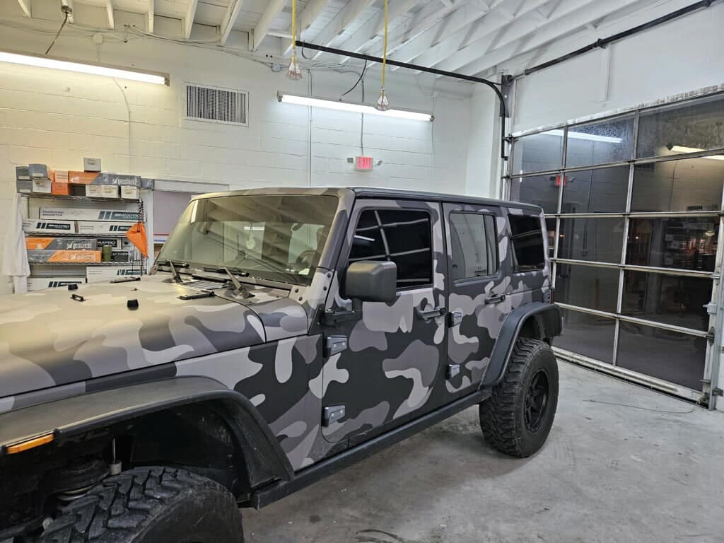 Camo wrapped Jeep Wrangler in the Classic Tint bay