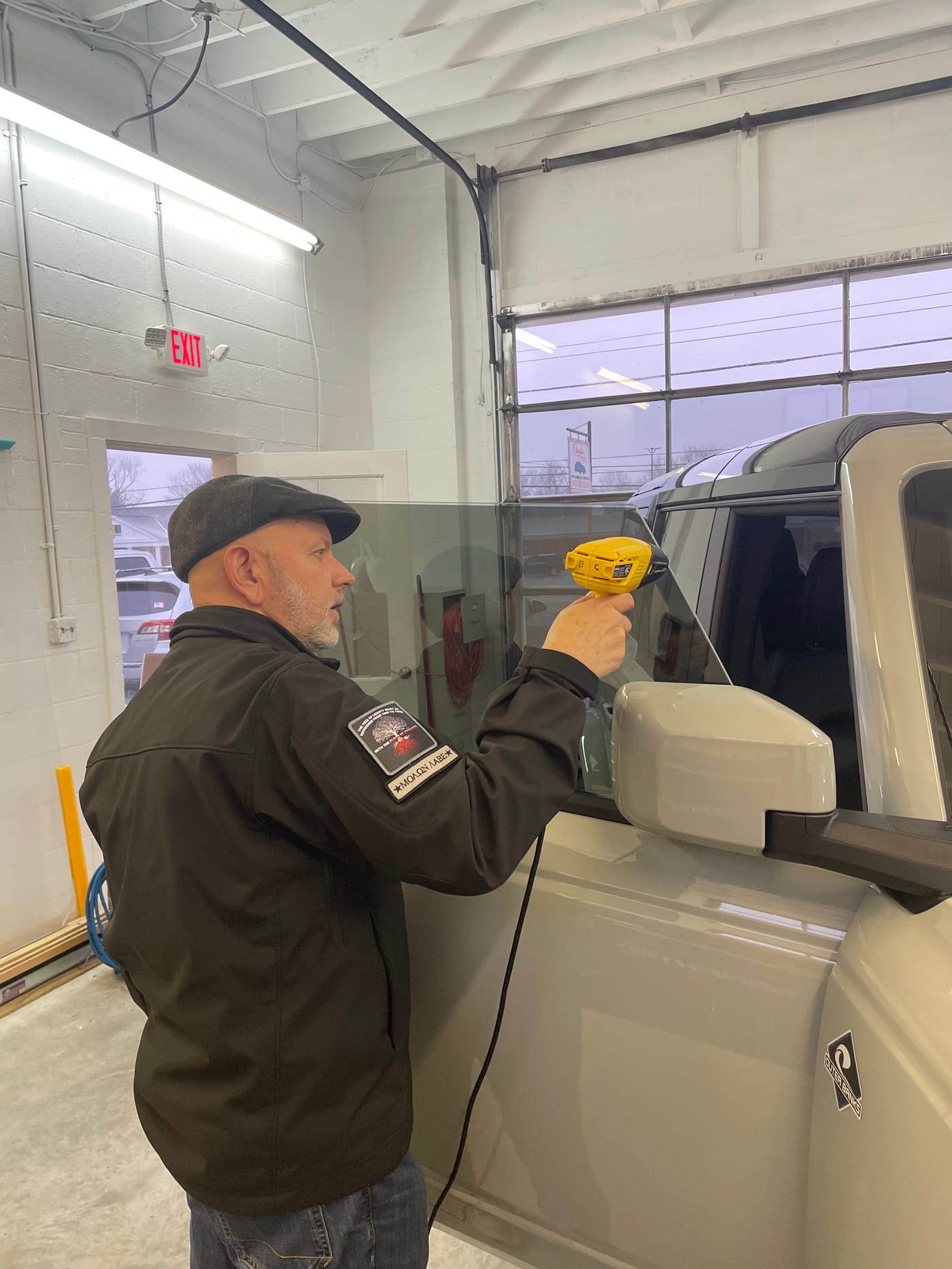 Classic Tint installer squeegeeing film onto glass